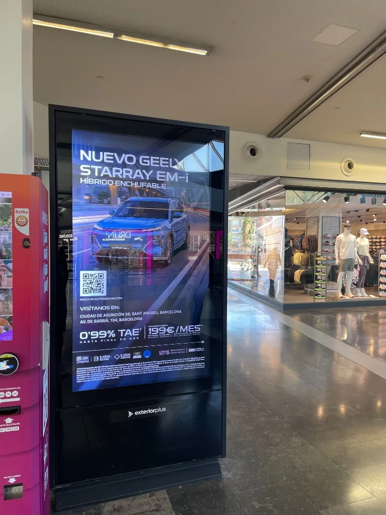 Tòtem digital de publicitat en zona de perfumeria i botigues d’un centre comercial