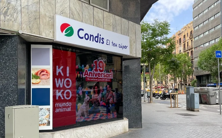 Pantalla digital publicitària de gran format en aparador de supermercat a Barcelona